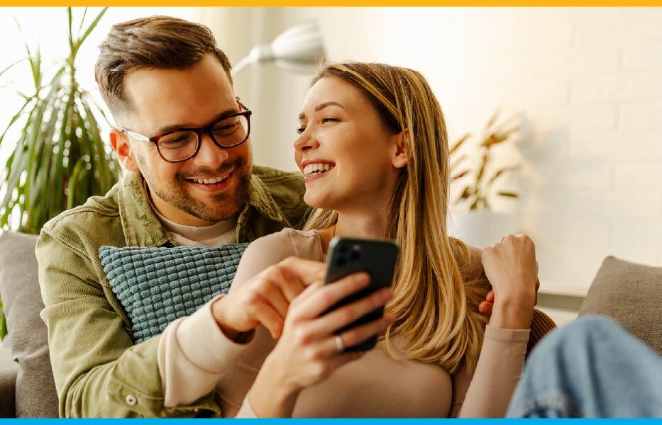 Man and woman couple exploring the condo ebook on a cellphone together Man and woman couple exploring the condo ebook on a cellphone together