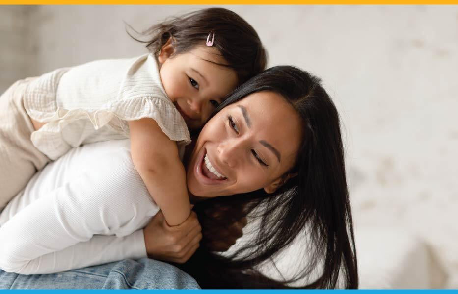 Asian mother with her daughter on her back, both laughing Asian mother with her daughter on her back, both laughing