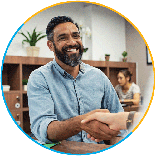 Middle-age smiling Indian man shaking hands with a business partner out of frame